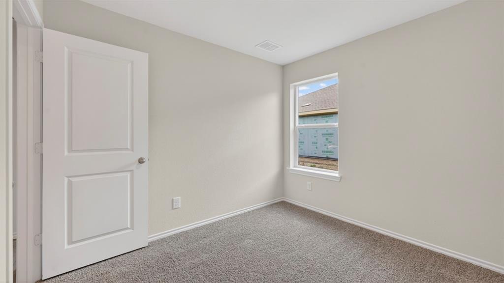 Neutral wall paint, gray carpeting, a two-panel interior door, and a single-pane window