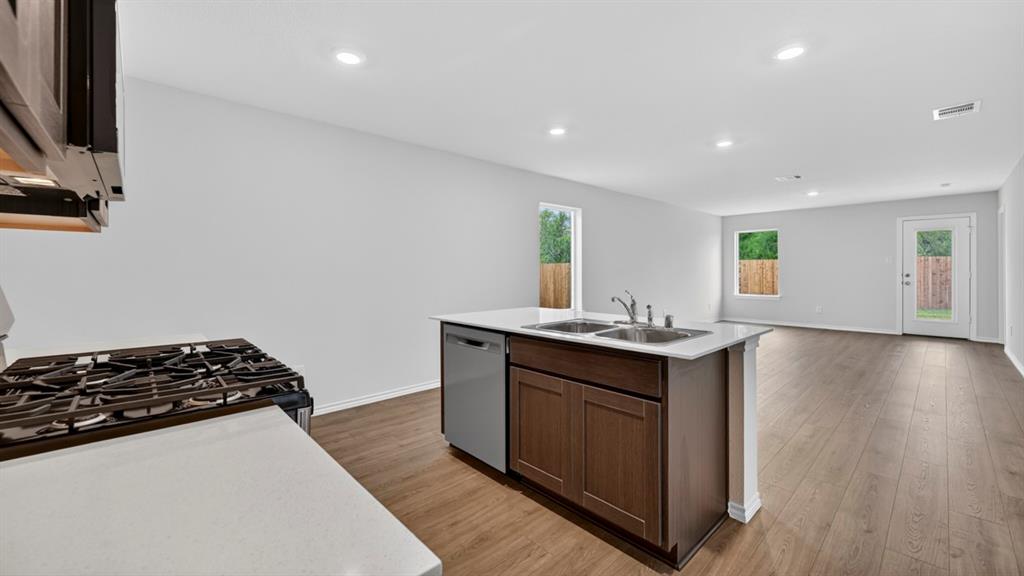Kitchen island with dual stainless steel sink, wood-finish cabinetry, and integrated dishwasher Kitchen island with dual stainless steel sink, wood-finish cabinetry, and integrated dishwasher