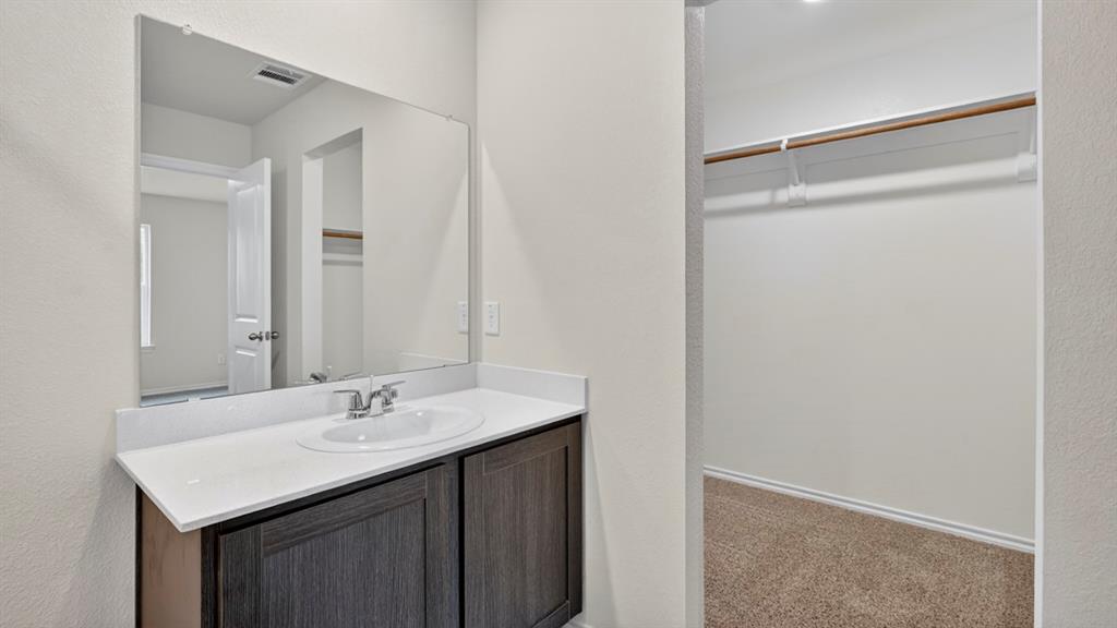 Bathroom vanity with an integrated sink, polished chrome faucet, and dark wood-finish cabinetry