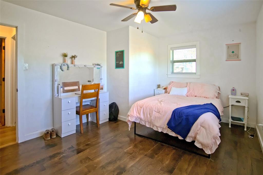 Wood-finish flooring, multi-light ceiling fan, and window with white trim