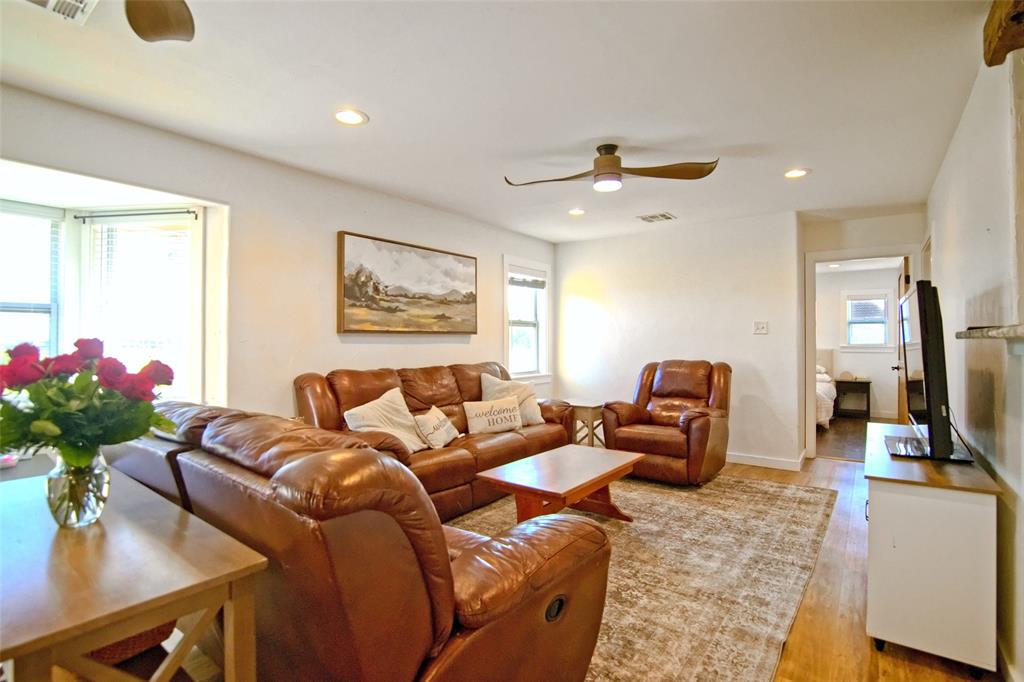 Living area featuring wood-finish flooring, recessed lighting, and a multi-blade ceiling fan