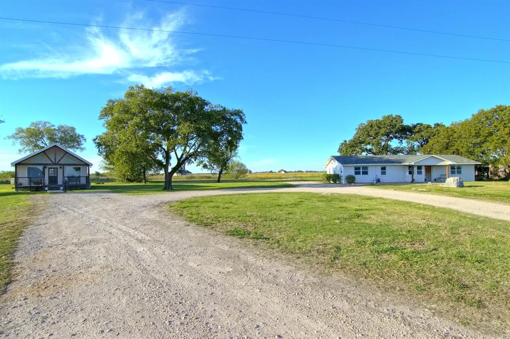 Expansive acreage featuring two detached residences, gravel driveway, mature trees, and open green space Expansive acreage featuring two detached residences, gravel driveway, mature trees, and open green space