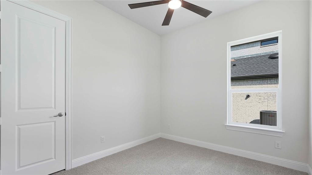 Room featuring neutral wall tones, wall-to-wall carpeting, a single-hung window, and a ceiling fan with integrated lighting