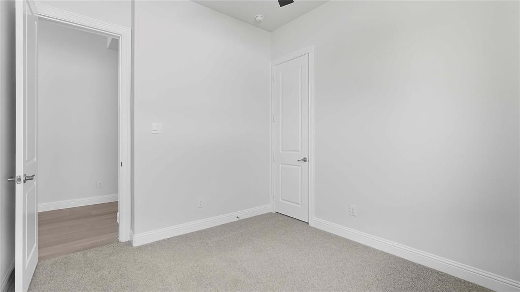 Interior space featuring neutral wall tones, plush wall-to-wall carpeting, and two-panel interior doors with satin nickel hardware
