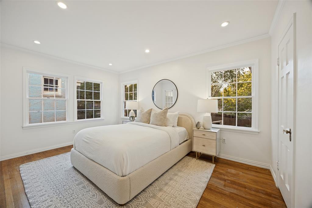 Bright room featuring wood-finish flooring, recessed lighting, multi-pane windows, and crown molding