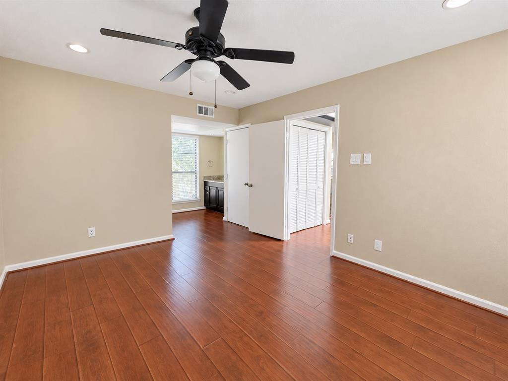 Room featuring wood-finish flooring, recessed lighting, and a multi-blade ceiling fan with a central light fixture