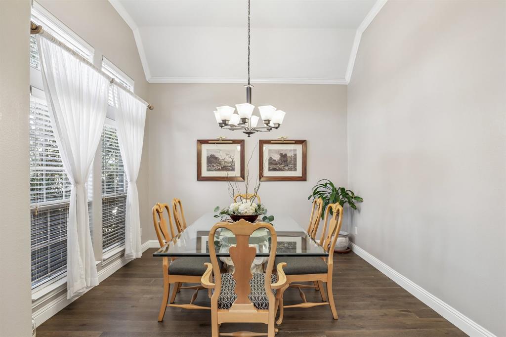Large dining room with vaulted ceiling, wood-finish flooring, and multi-light chandelier fixture Large dining room with vaulted ceiling, wood-finish flooring, and multi-light chandelier fixture