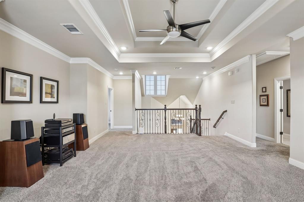Second floor living room featuring tray ceiling featuring crown molding and a center-mounted ceiling fan with integrated lighting, recessed lighting, and carpeted flooring