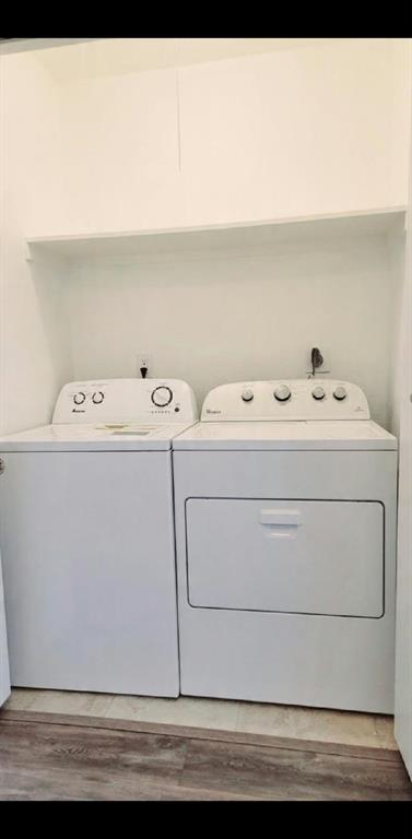 Dedicated laundry closet featuring a built-in overhead storage shelf, tile flooring, and standard washer and dryer hookups