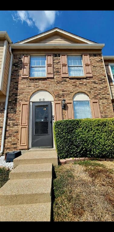 Brick facade exterior featuring arched entryway detailing, window shutters, and concrete stairs