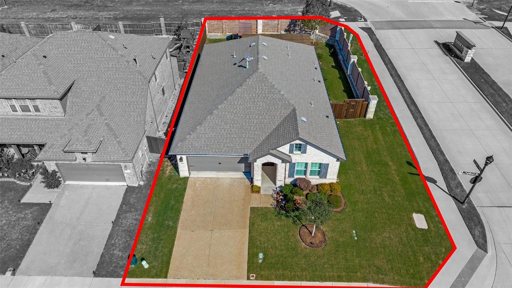 Single-story brick exterior residence featuring a composite shingle roof, attached garage, concrete driveway, and a fenced backyard
