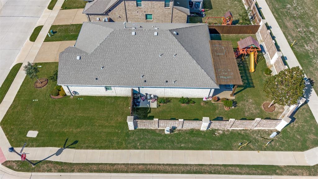 Corner lot exterior featuring a masonry fence, a pergola-covered patio, and a side-load garage