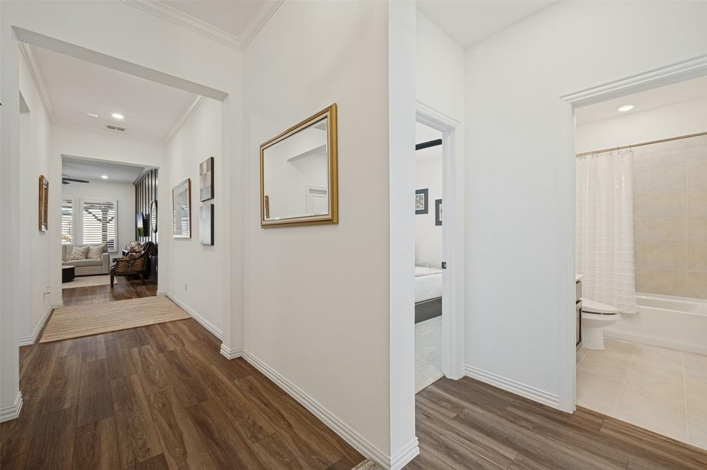 Interior hallway featuring wood-finish flooring, crisp white walls, crown molding, and recessed lighting Interior hallway featuring wood-finish flooring, crisp white walls, crown molding, and recessed lighting