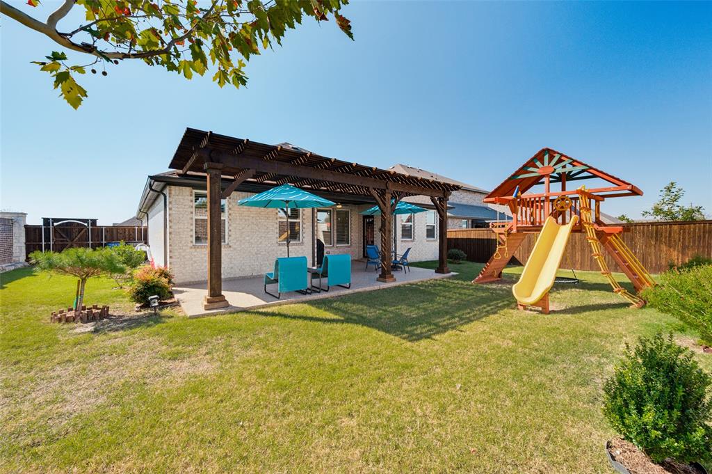 Backyard featuring a covered patio with a wooden pergola, concrete surfacing, fenced perimeter, and a grass lawn