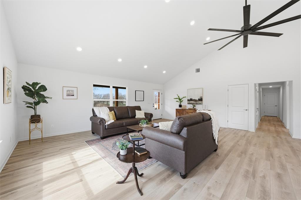 Vaulted ceilings, wood-finish flooring, recessed lighting, and a multi-blade ceiling fan Vaulted ceilings, wood-finish flooring, recessed lighting, and a multi-blade ceiling fan