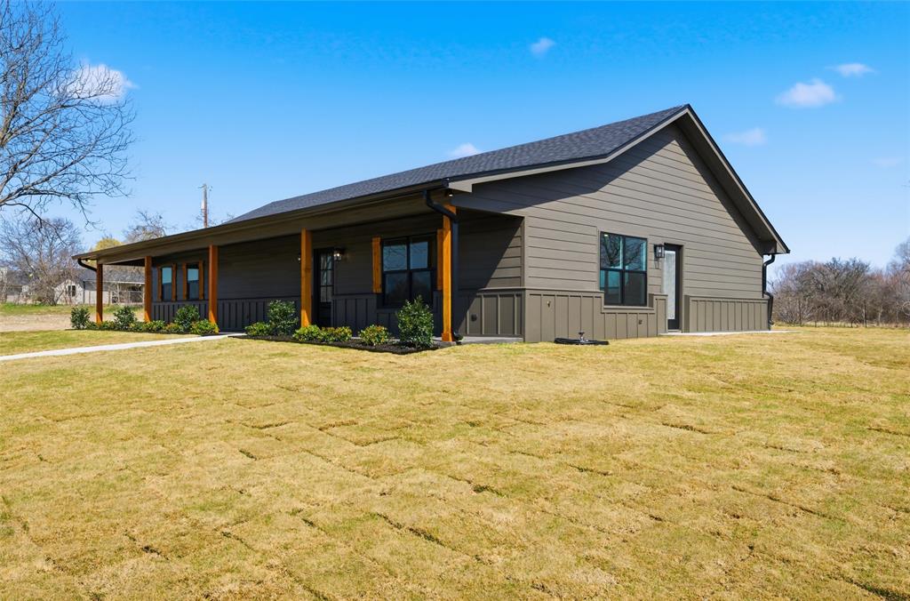Modern exterior featuring horizontal and vertical siding, a covered porch with timber support beams, and black-framed windows
