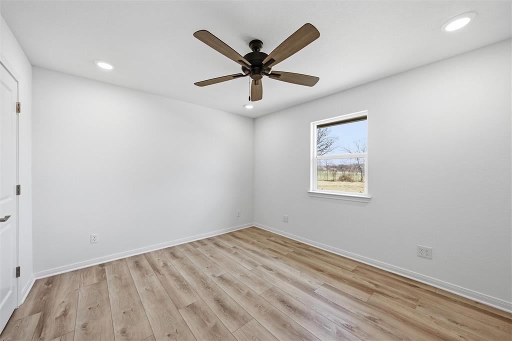 Room featuring wood-finish flooring, recessed lighting, and a multi-blade ceiling fan