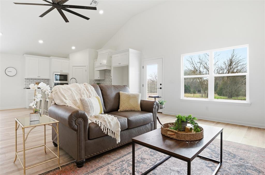 Vaulted ceilings, wood-finish flooring, recessed lighting, and a large window with exterior natural light Vaulted ceilings, wood-finish flooring, recessed lighting, and a large window with exterior natural light
