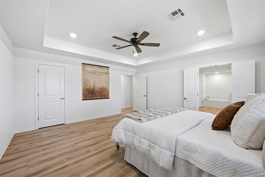 Tray ceiling featuring recessed lighting, wood-finish flooring, and a multi-blade ceiling fan