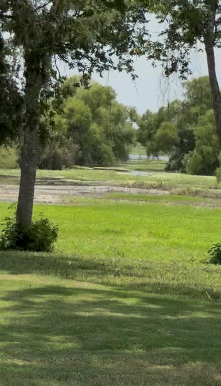 Expansive grounds featuring mature shade trees, established lawn, and open natural landscape