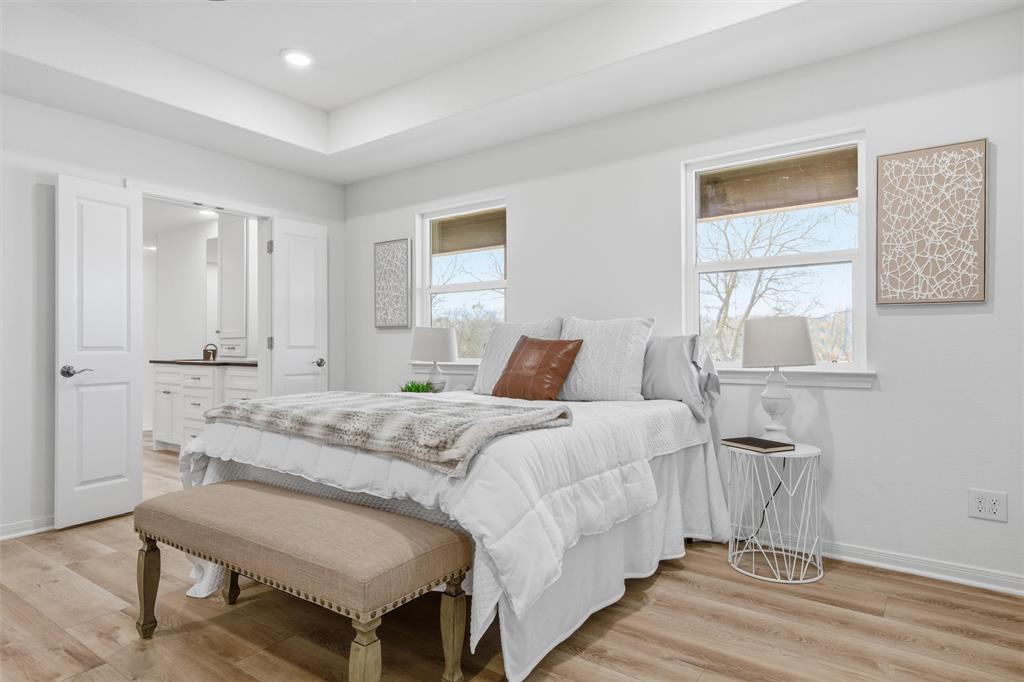 Bedroom featuring wood-finish flooring, a recessed tray ceiling, recessed lighting, and dual windows