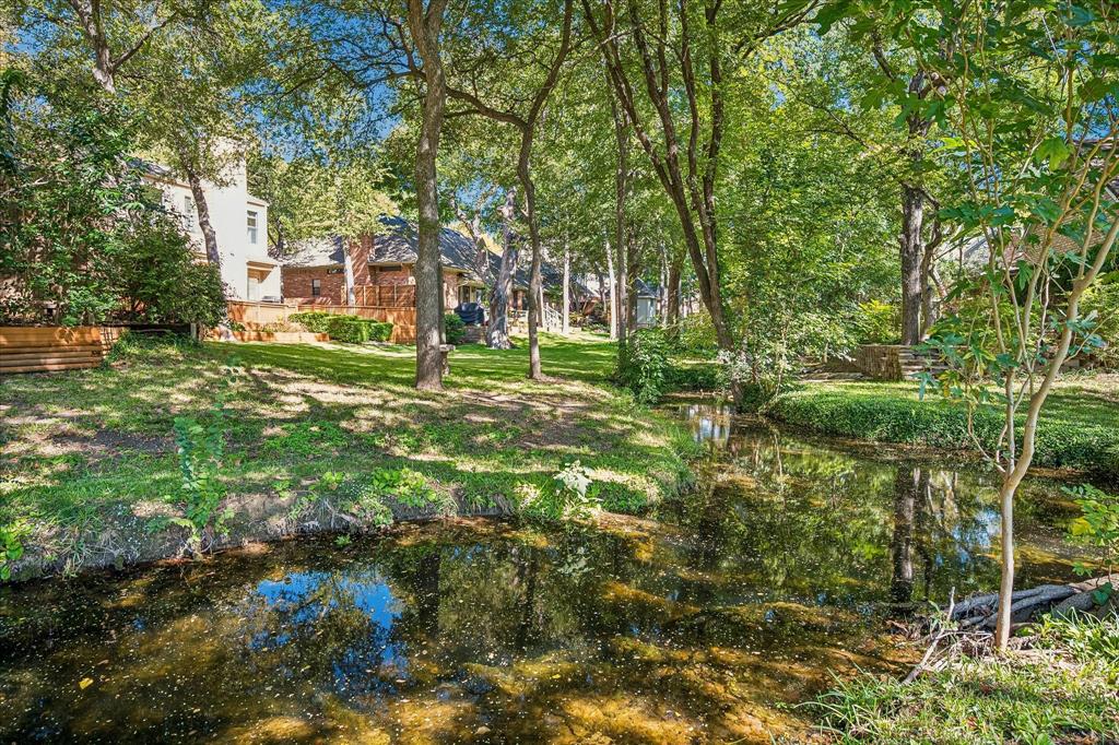 A view of the creek running through the neighborhood which is a view of the backyard of the property looking from the other side of the creek.