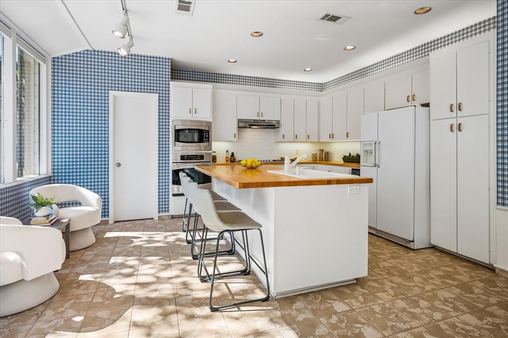 The kitchen has newly refinished butcher block wood countertops and a large island with a sink.  The breakfast area can either be used as a siting area as shown or can provide additional eating space with a table and chairs.
