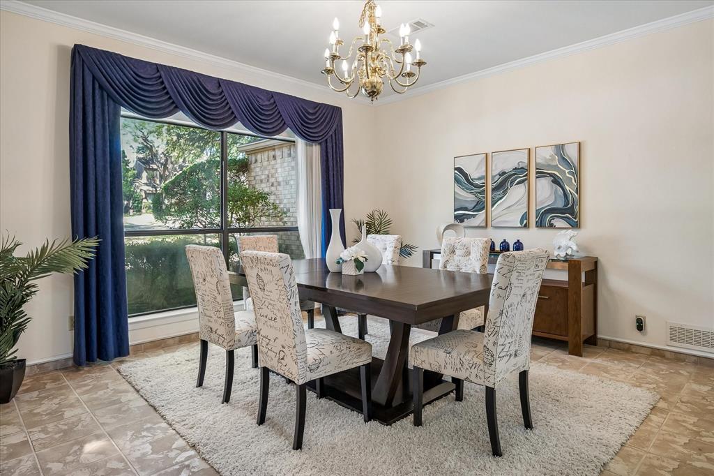Large dining area with a chandelier and large windows which you can see views of the golf course across the street.