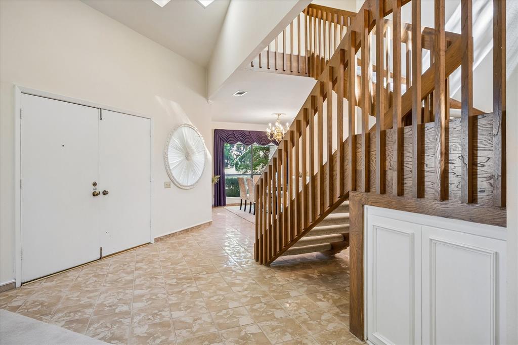 Front entry way welcomes you with imported polished tile from Italy showcasing the uniquely designed wooden staircase.  Upon entry into the home you are met with high ceiling providing a spacious feeling.
