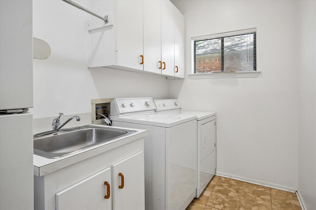 Spacious laundry room with a sink, plenty of storage with connections to full-size washer and dryer and room for a refrigerator.  The appliance stay with the sale of the home.