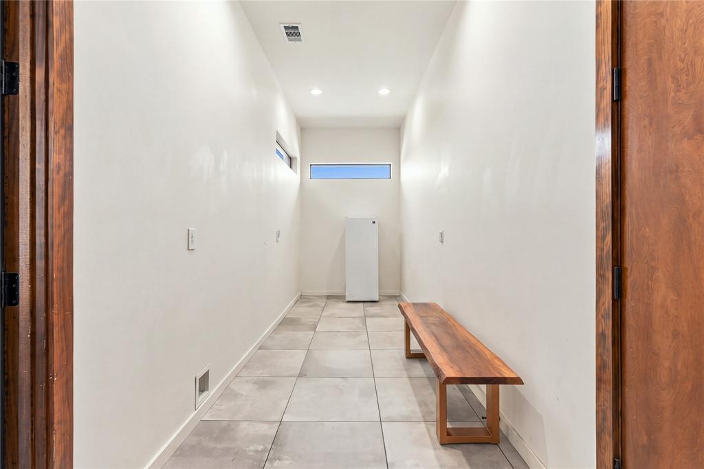 Large-format tile flooring, recessed ceiling lighting, and clerestory windows