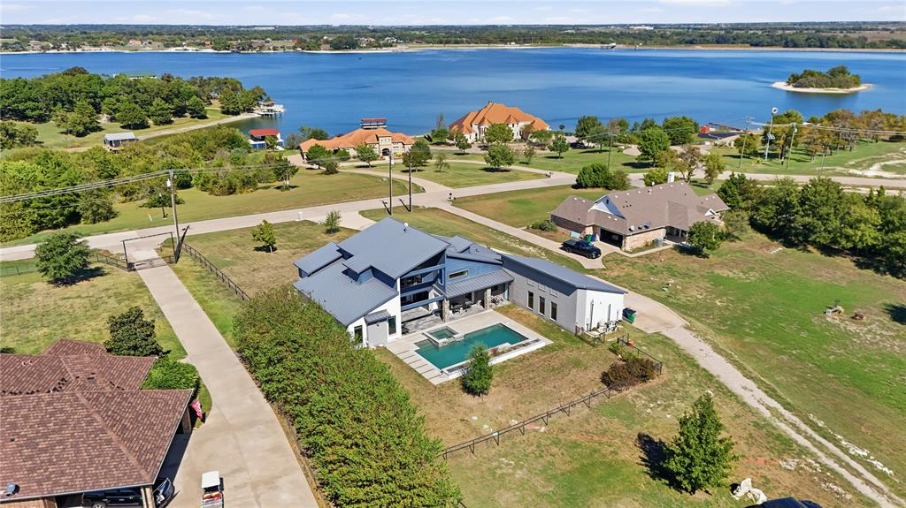 Modern multi-level exterior with metal roofing, in-ground swimming pool, integrated spa, and expansive water frontage