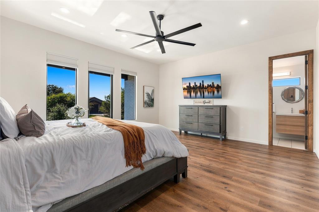 Wood-finish flooring, recessed lighting, matte black ceiling fan, and large windows with roller shades