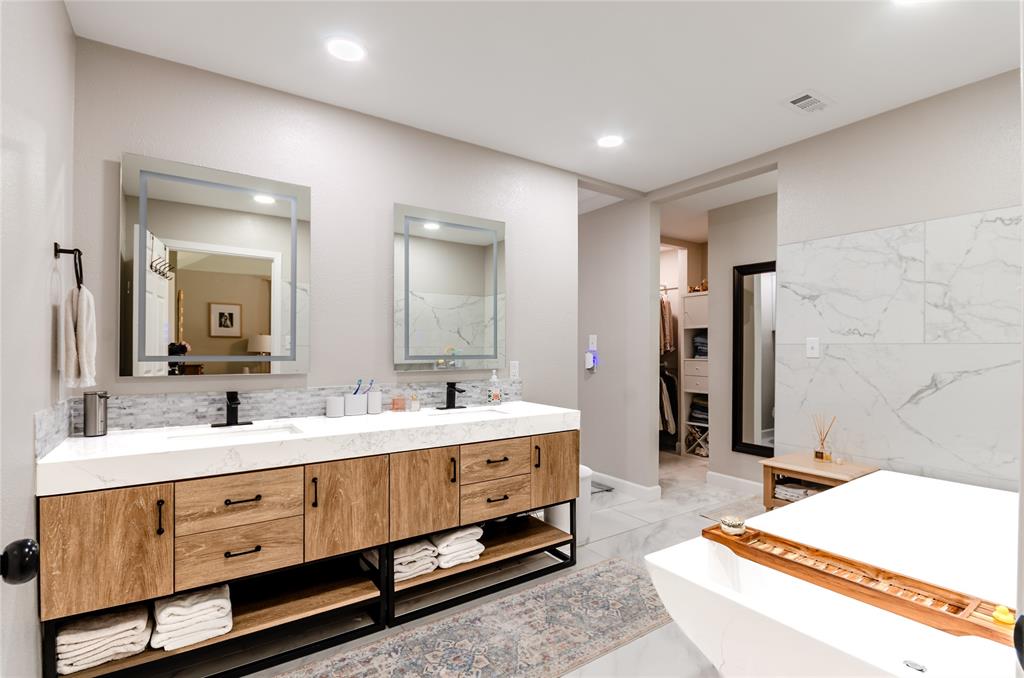 Dual vanity with wood-finish cabinetry, white countertop, and integrated sinks