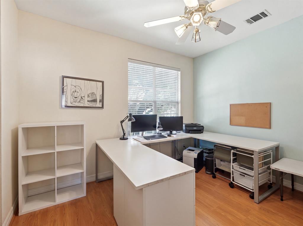 Wood-finish flooring, central window with blinds, and ceiling fan with integrated lighting