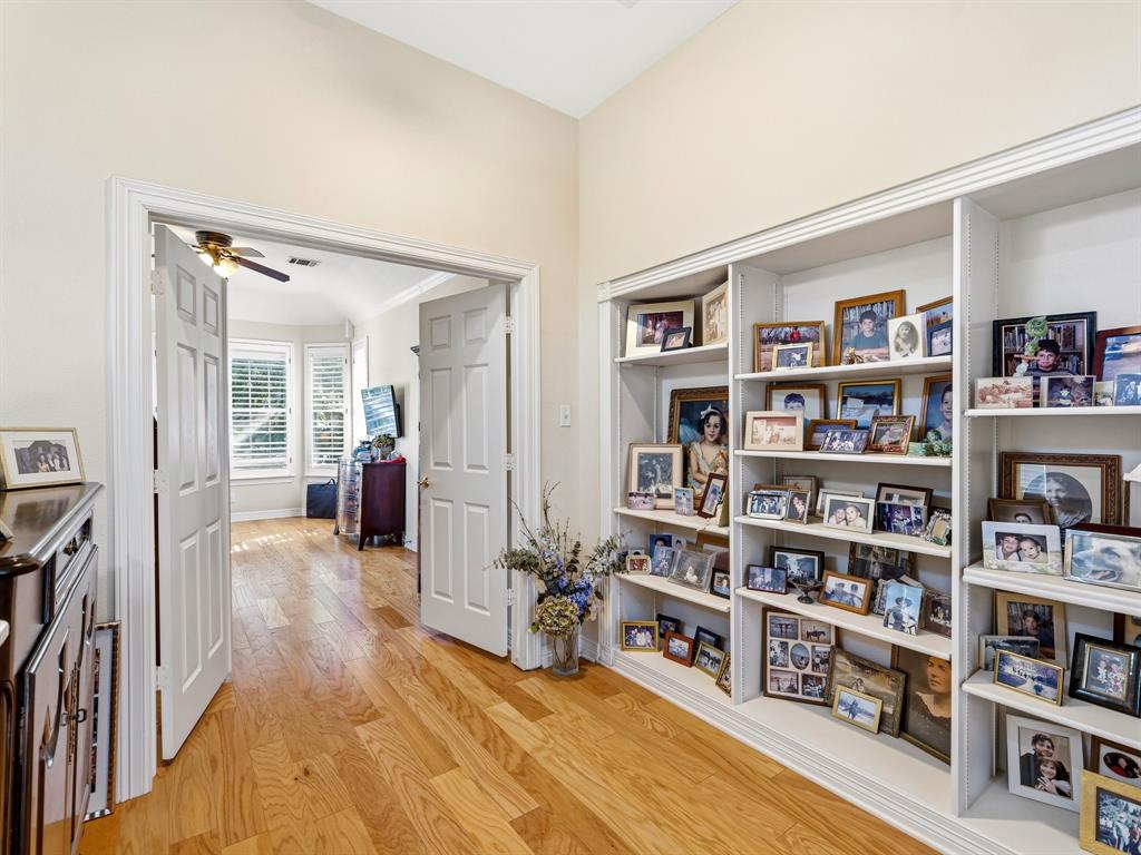 Built-in floor-to-ceiling shelving, wood-finish flooring, and arched double-door entry