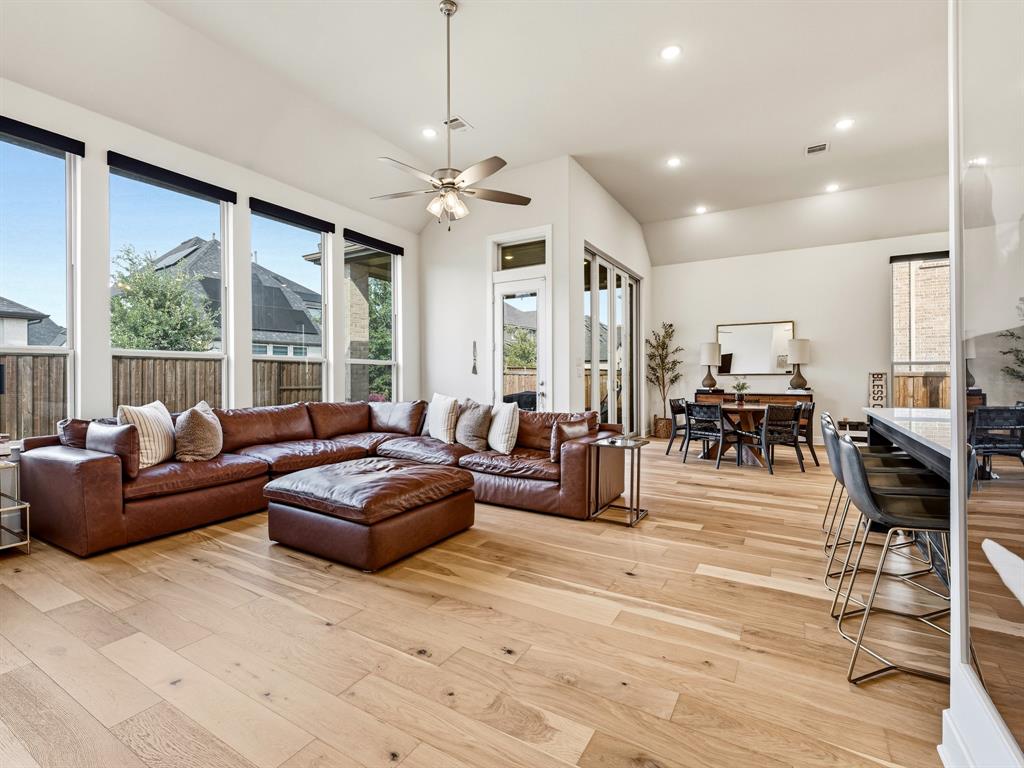 Vaulted ceilings, expansive floor-to-ceiling windows, recessed lighting, and wood-finish flooring