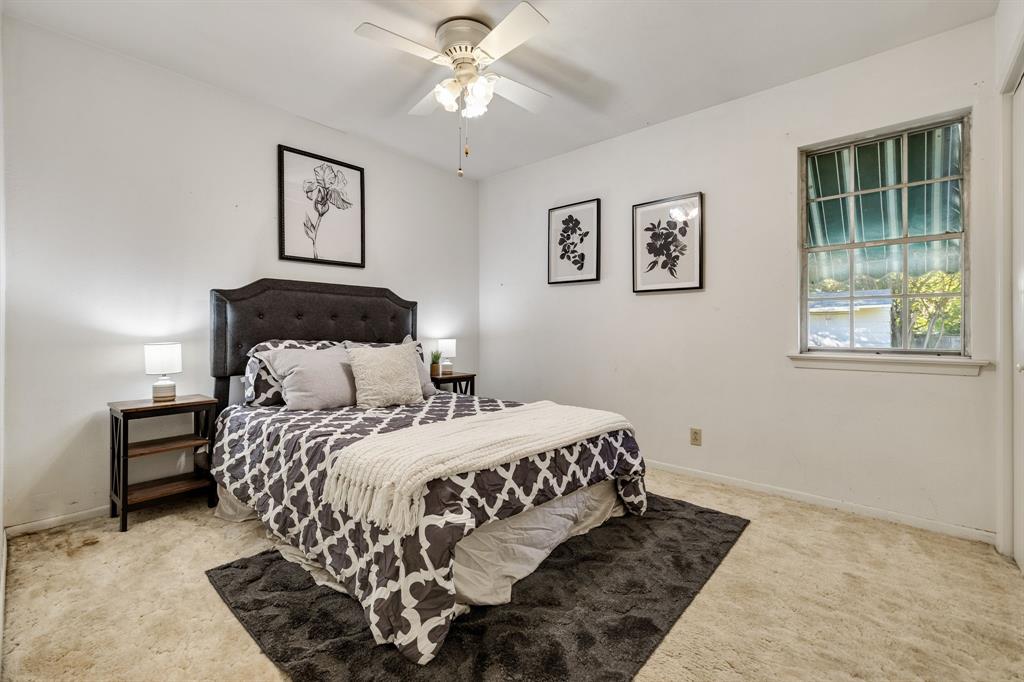 Room featuring neutral wall finishes, carpeted flooring, a ceiling fan with integrated lighting, and a multi-pane window with an exterior metal awning