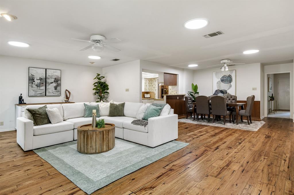 Open-concept floor plan featuring wood-finish flooring, recessed lighting, ceiling fans, and a pass-through opening