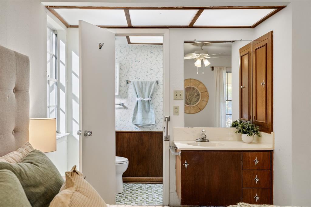 Bathroom vanity featuring wooden cabinetry, integrated countertop with a recessed basin, and wall-mounted wooden medicine cabinet