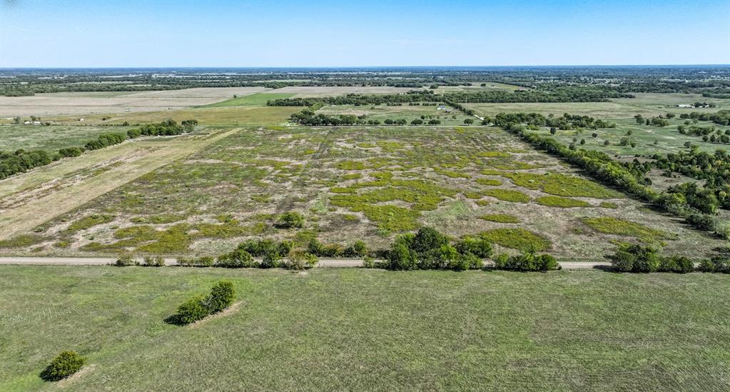 Expansive acreage featuring cleared level terrain, mature tree clusters, and direct road frontage Expansive acreage featuring cleared level terrain, mature tree clusters, and direct road frontage