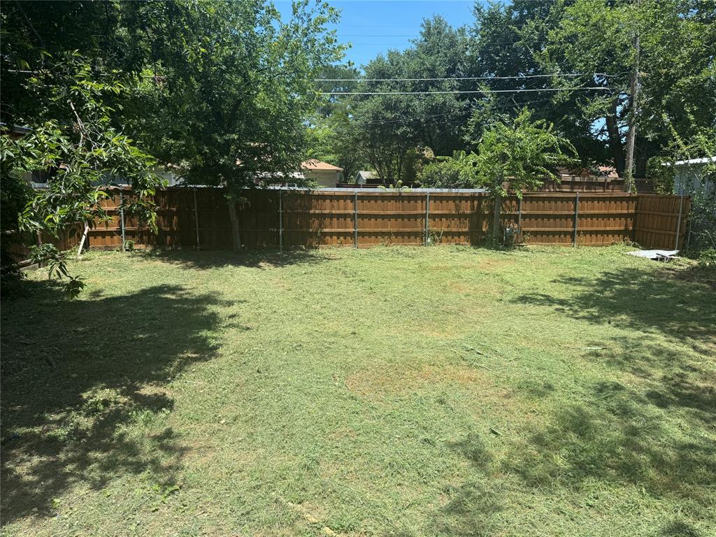 Expansive backyard featuring a fenced perimeter and mature trees