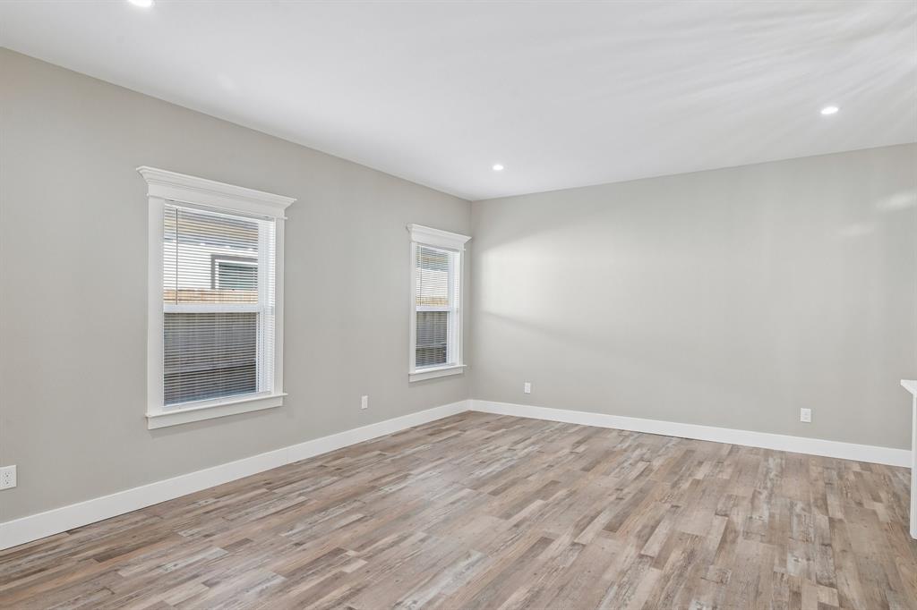 Neutral-toned walls, wood-finish flooring, recessed lighting, and double-hung windows with decorative crown molding trim