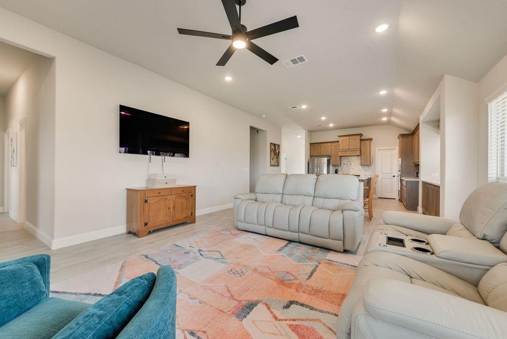 Vaulted ceilings with recessed lighting, matte black ceiling fan, wood-finish flooring, and neutral wall color Vaulted ceilings with recessed lighting, matte black ceiling fan, wood-finish flooring, and neutral wall color