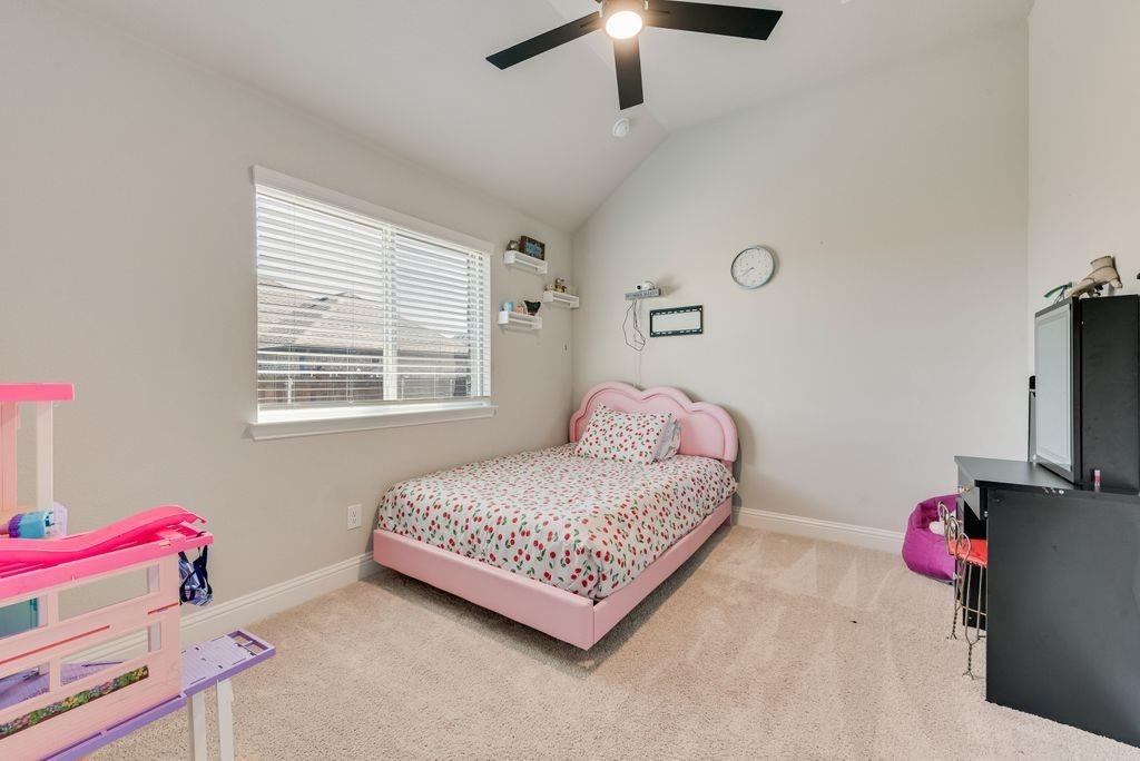 Vaulted ceilings, neutral wall color, wall-to-wall carpeting, horizontal window blinds, and a matte black ceiling fan with integrated lighting