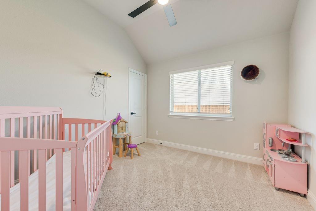 Vaulted ceiling featuring a ceiling fan, neutral carpeting, and a window with horizontal blinds