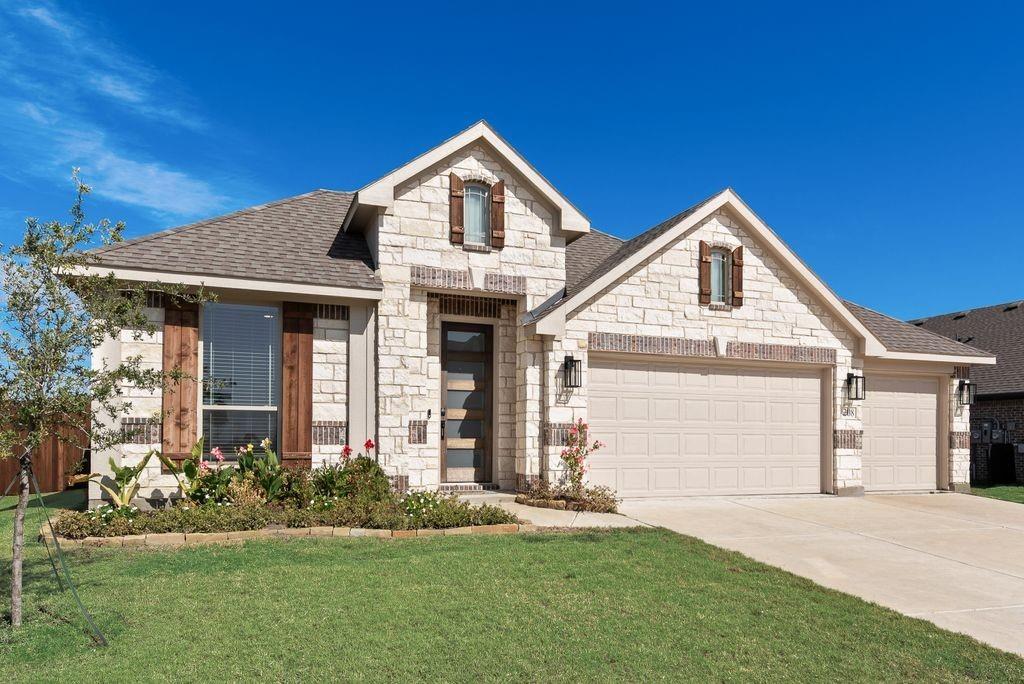 Stone facade exterior featuring wooden window shutters, a multi-car garage, and architectural gables
