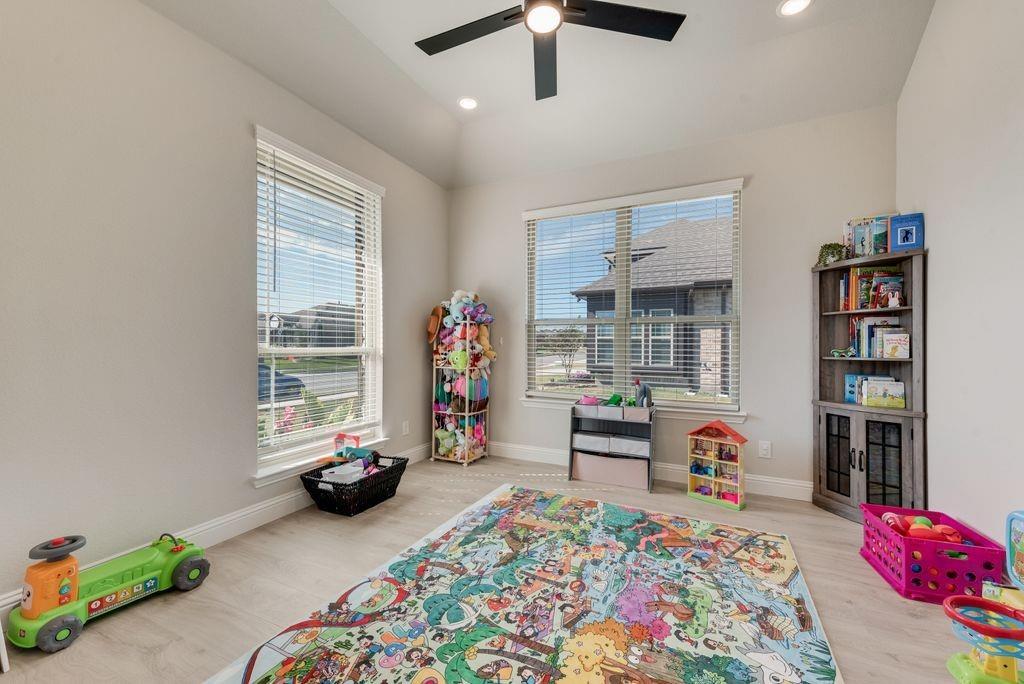 Vaulted ceiling featuring a matte black finish ceiling fan and recessed lighting, neutral interior paint, and wood-finish flooring Vaulted ceiling featuring a matte black finish ceiling fan and recessed lighting, neutral interior paint, and wood-finish flooring