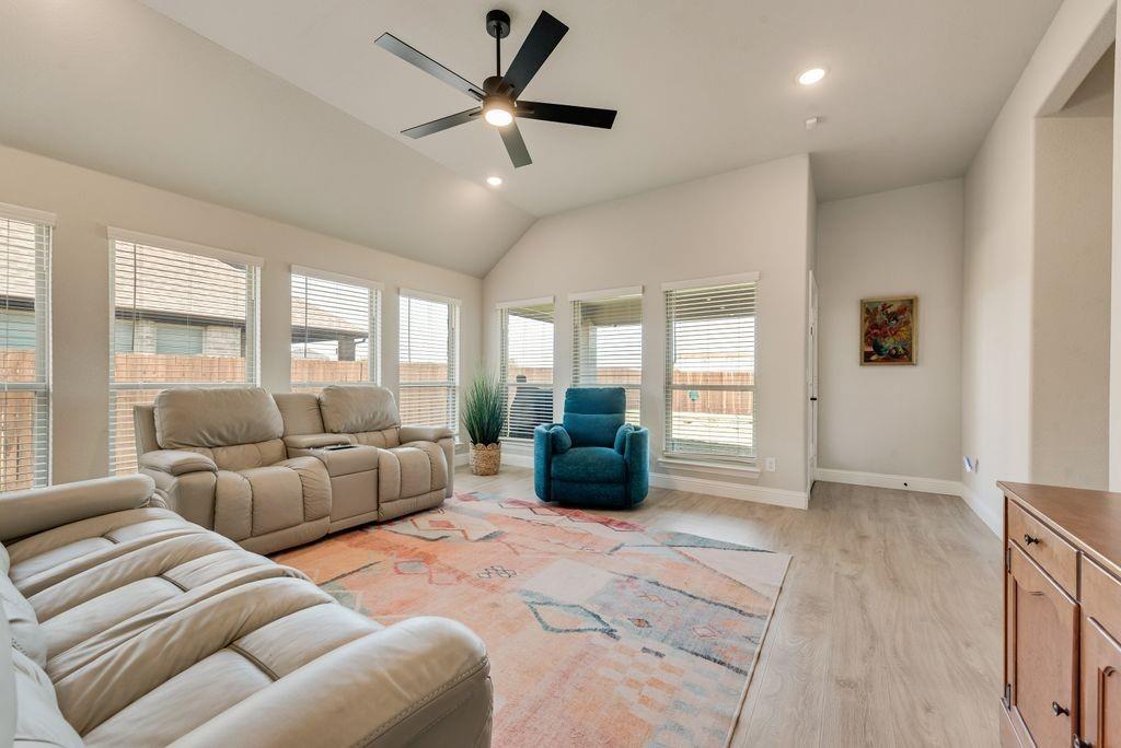 Vaulted ceilings, wood-finish flooring, six large windows, and a matte black ceiling fan with integrated lighting Vaulted ceilings, wood-finish flooring, six large windows, and a matte black ceiling fan with integrated lighting