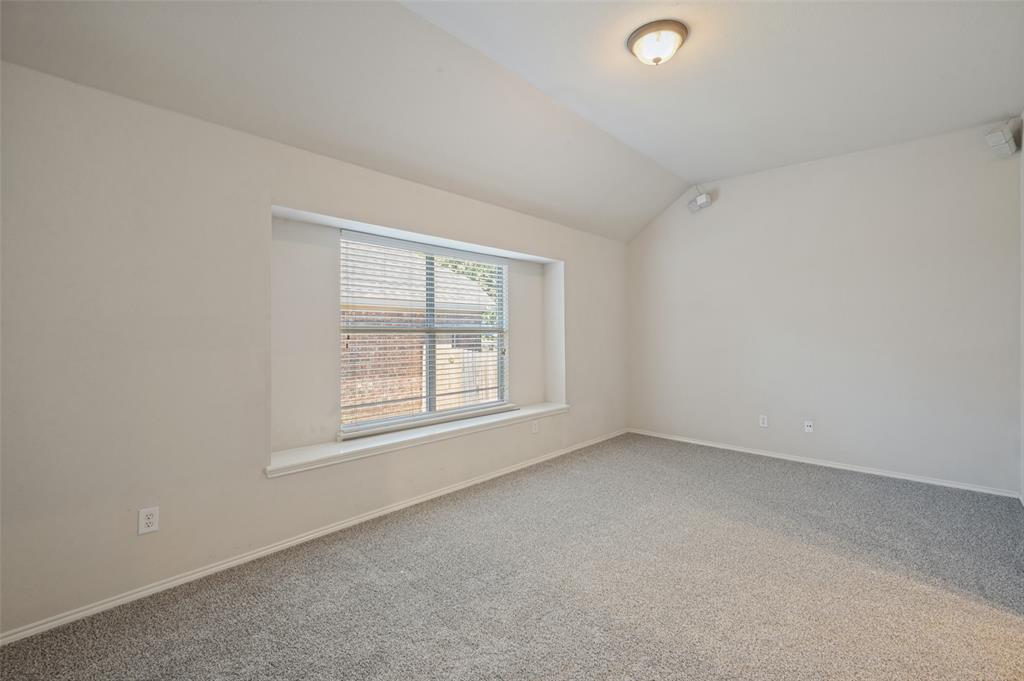 Vaulted ceilings, neutral wall color, carpeted flooring, and a recessed window with a built-in sill